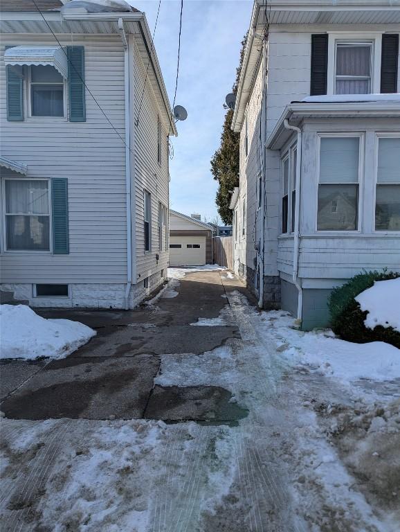 view of snowy exterior with a garage and an outdoor structure