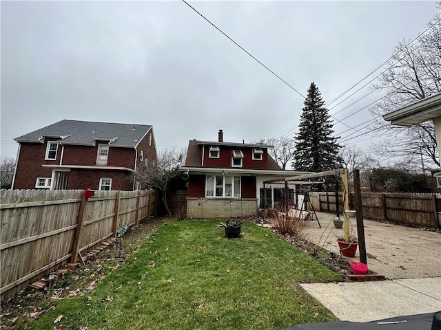 rear view of property featuring a patio area and a lawn