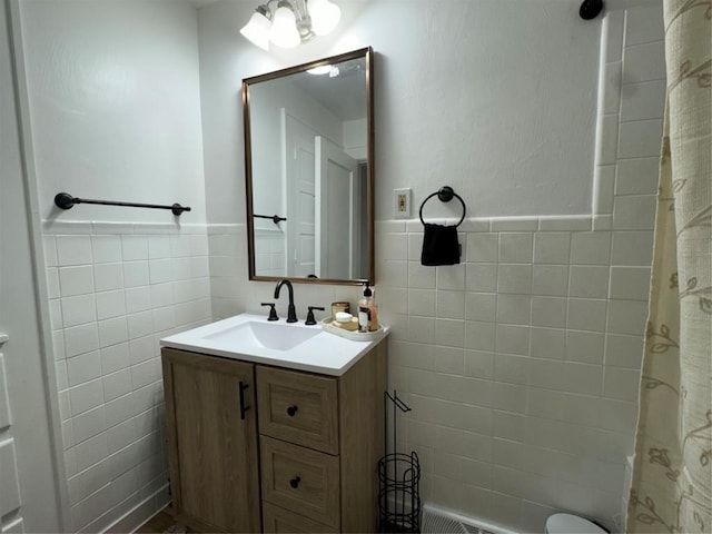 bathroom with vanity and tile walls