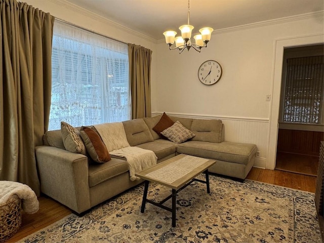 living room featuring hardwood / wood-style flooring, ornamental molding, and a chandelier