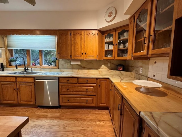 kitchen with sink, wooden counters, dishwasher, light hardwood / wood-style floors, and backsplash