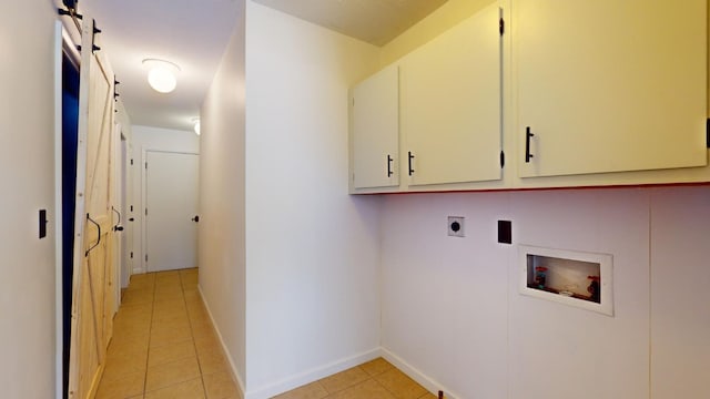 washroom featuring cabinets, washer hookup, electric dryer hookup, a barn door, and light tile patterned flooring