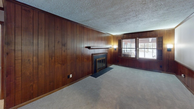 unfurnished living room featuring light carpet, a textured ceiling, ornamental molding, and wood walls