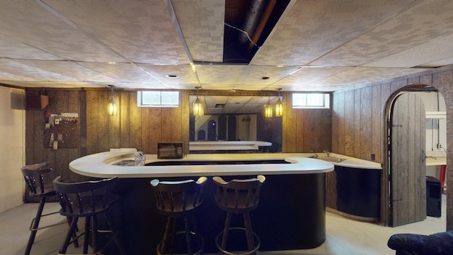 bar featuring wood walls and concrete floors