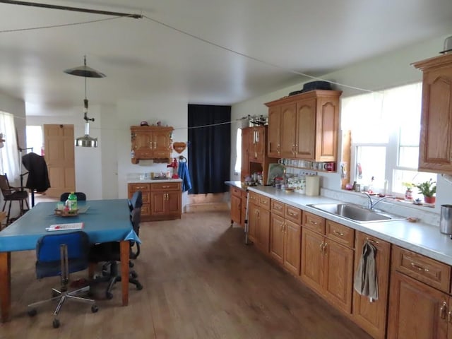 kitchen with sink, hanging light fixtures, and dark wood-type flooring