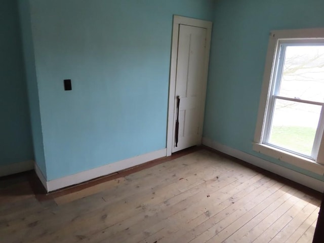 spare room featuring light hardwood / wood-style flooring and a healthy amount of sunlight