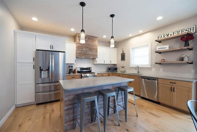 7662 Magnolia Bnd, Fairview, PA 16415 - kitchen with appliances with stainless steel finishes, light wood finished floors, a breakfast bar, a center island, and recessed lighting