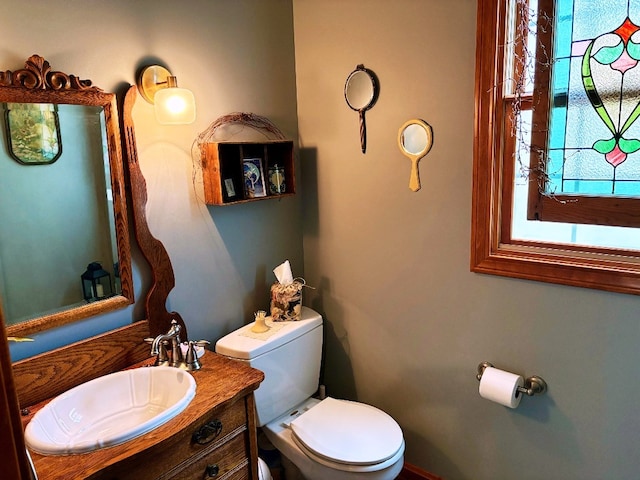 half bath featuring vanity and toilet