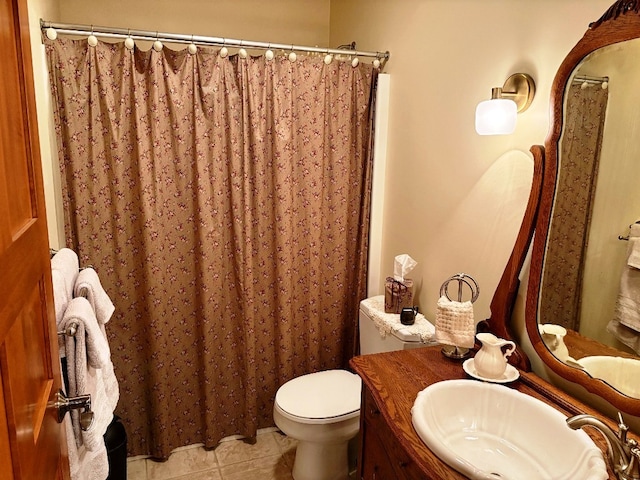 bathroom featuring vanity, a shower with shower curtain, tile patterned floors, and toilet