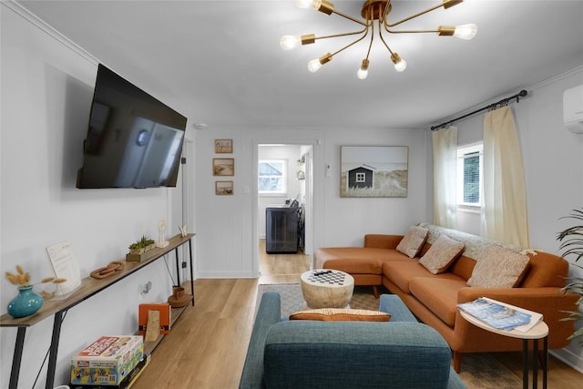 living area featuring a notable chandelier, light wood-type flooring, crown molding, and a healthy amount of sunlight