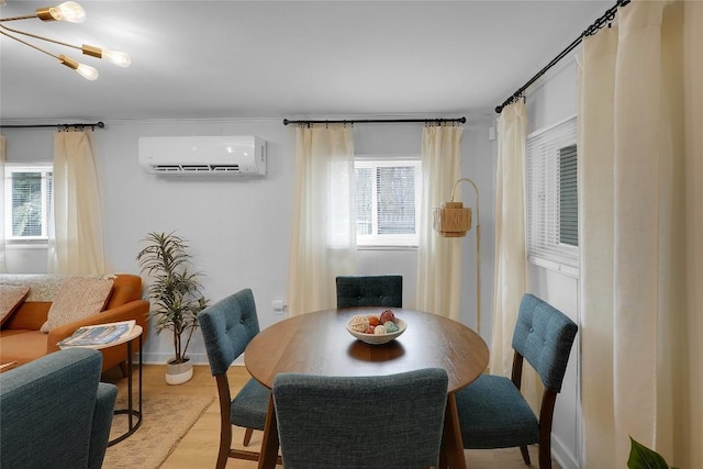 dining room featuring a wealth of natural light, light wood-style flooring, and a wall unit AC