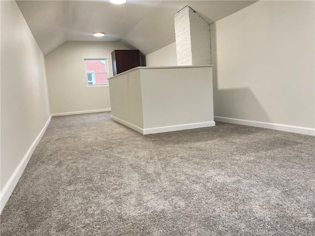 additional living space featuring carpet flooring and lofted ceiling