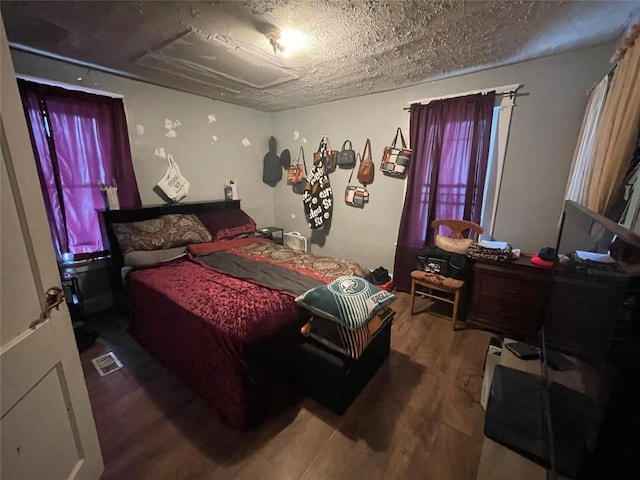 bedroom featuring wood-type flooring and a textured ceiling