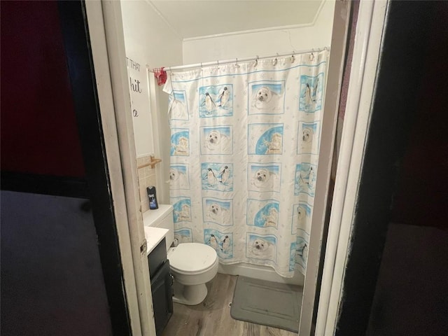 full bathroom with toilet, hardwood / wood-style floors, vanity, and shower / bath combo with shower curtain