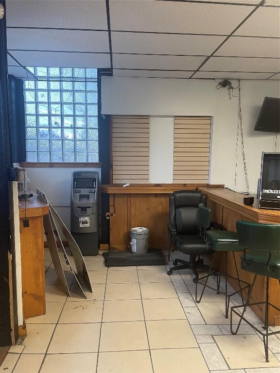 tiled home office with a paneled ceiling