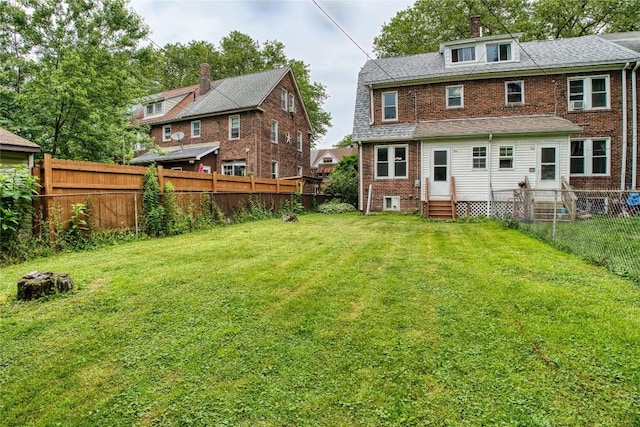 1032 Newton Ave, Erie, PA 16511 - rear view of property featuring entry steps, brick siding, a fenced backyard, and a chimney