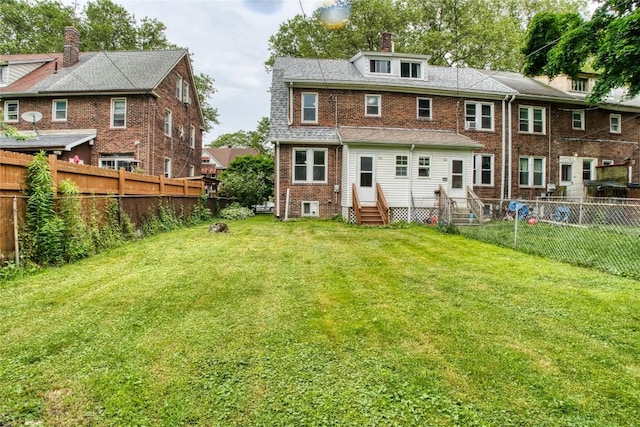 1032 Newton Ave, Erie, PA 16511 - back of property with entry steps, brick siding, a fenced backyard, and a chimney
