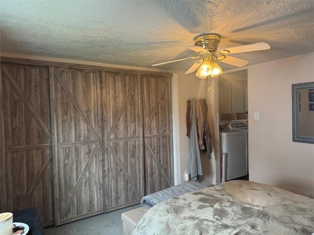 bedroom featuring carpet flooring, washer and dryer, a ceiling fan, and a textured ceiling