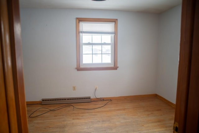 unfurnished room featuring light hardwood / wood-style floors and a baseboard heating unit