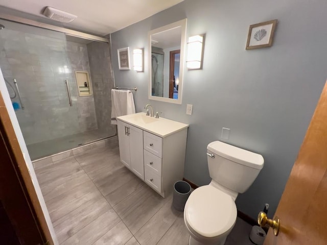 bathroom with an enclosed shower, vanity, and toilet