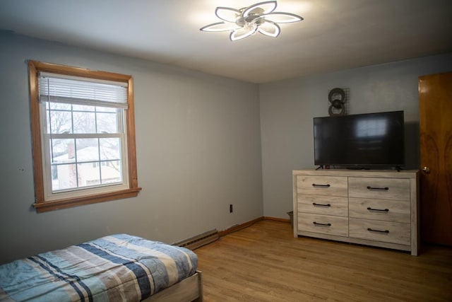 bedroom featuring hardwood / wood-style flooring and baseboard heating