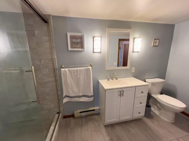 bathroom featuring baseboard heating, vanity, toilet, and an enclosed shower