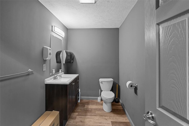11221 W Greene Rd, Waterford, PA 16441 - half bath featuring toilet, wood finished floors, a textured ceiling, vanity, and baseboards