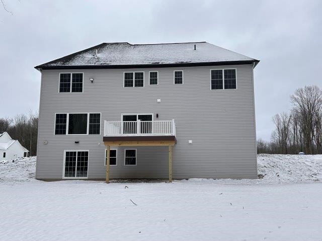 view of snow covered back of property