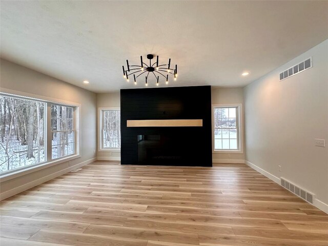 kitchen with a kitchen island with sink, sink, decorative light fixtures, dishwasher, and light hardwood / wood-style floors