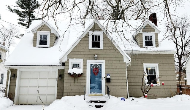 cape cod home featuring a garage