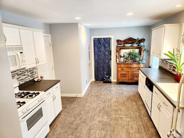 kitchen featuring decorative backsplash, white cabinetry, and white appliances