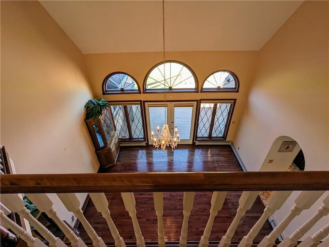 entryway with dark wood-type flooring and a chandelier