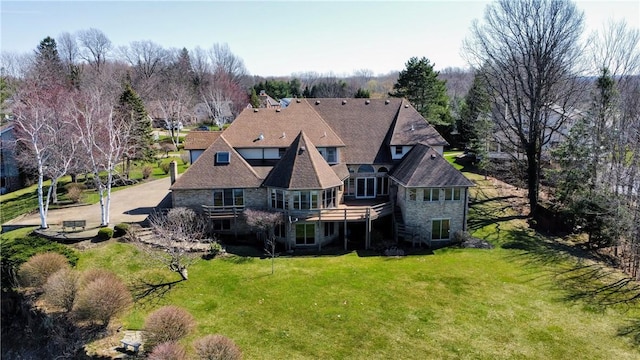 rear view of house with a lawn and a wooden deck