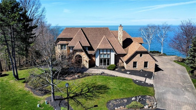 tudor home with a front lawn and a water view