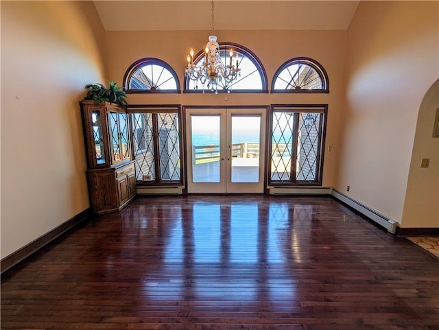 entryway featuring a high ceiling, french doors, dark hardwood / wood-style floors, a baseboard radiator, and a notable chandelier