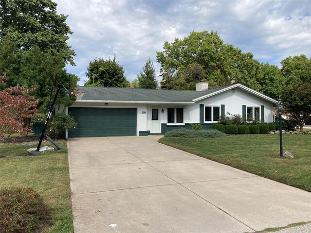 single story home with a garage and a front lawn