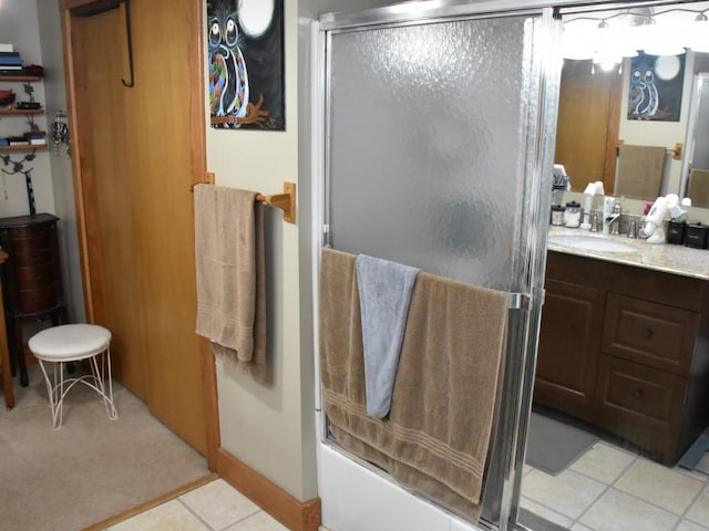 bathroom with vanity, tile patterned floors, and bath / shower combo with glass door