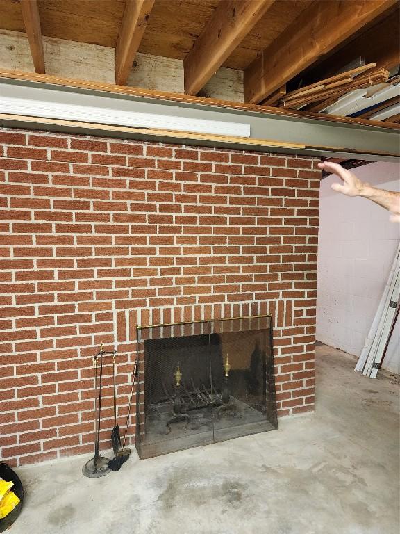 interior details featuring a brick fireplace and concrete flooring