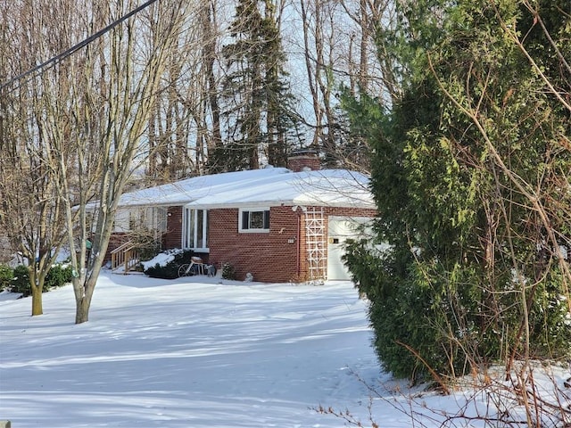 snow covered property with a garage