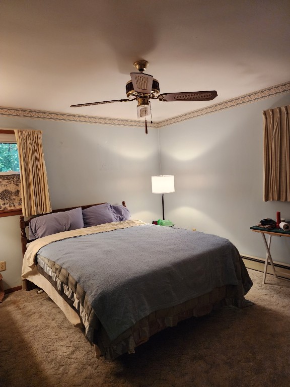 bedroom featuring ceiling fan, a baseboard radiator, and carpet