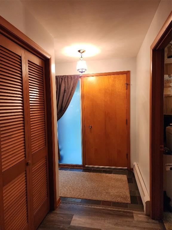 hall featuring dark wood-type flooring and baseboard heating