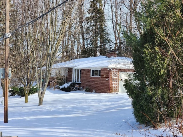 view of snow covered exterior featuring a garage