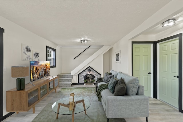 living room with a textured ceiling and light hardwood / wood-style flooring