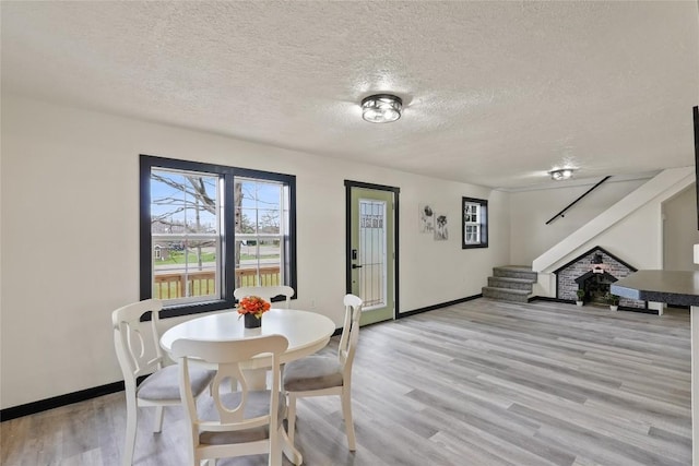 dining room with a textured ceiling and light hardwood / wood-style flooring