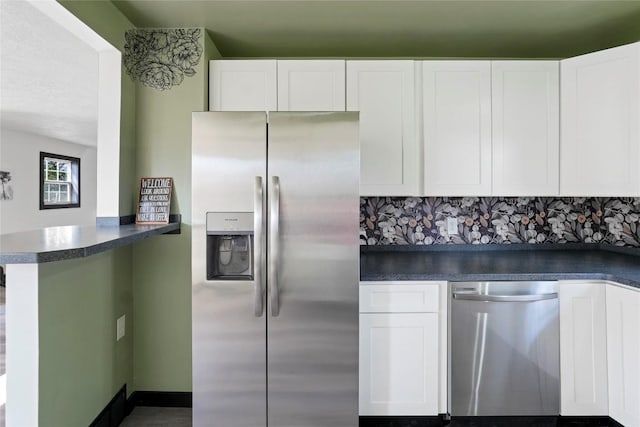 kitchen featuring kitchen peninsula, white cabinets, decorative backsplash, and stainless steel appliances