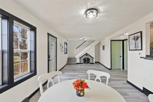 dining space featuring a textured ceiling and light wood-type flooring