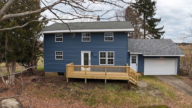 rear view of property with a deck and a garage