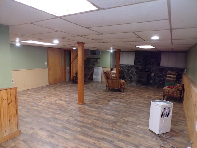 13326 Ridge Rd, West Springfield, PA 16443 - finished below grade area with wood finished floors, a paneled ceiling, stairs, a wood stove, and a wainscoted wall