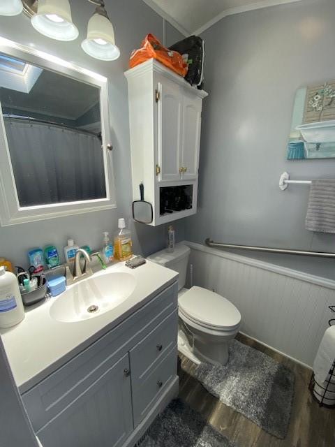 831 Douglas Dr, Erie, PA 16505 - full bath featuring wood finished floors, vanity, a wainscoted wall, and toilet