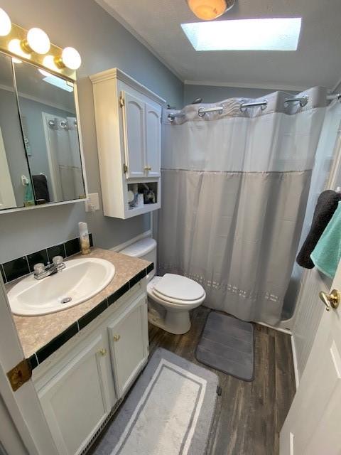 831 Douglas Dr, Erie, PA 16505 - full bathroom featuring a skylight, wood finished floors, vanity, toilet, and a shower with shower curtain